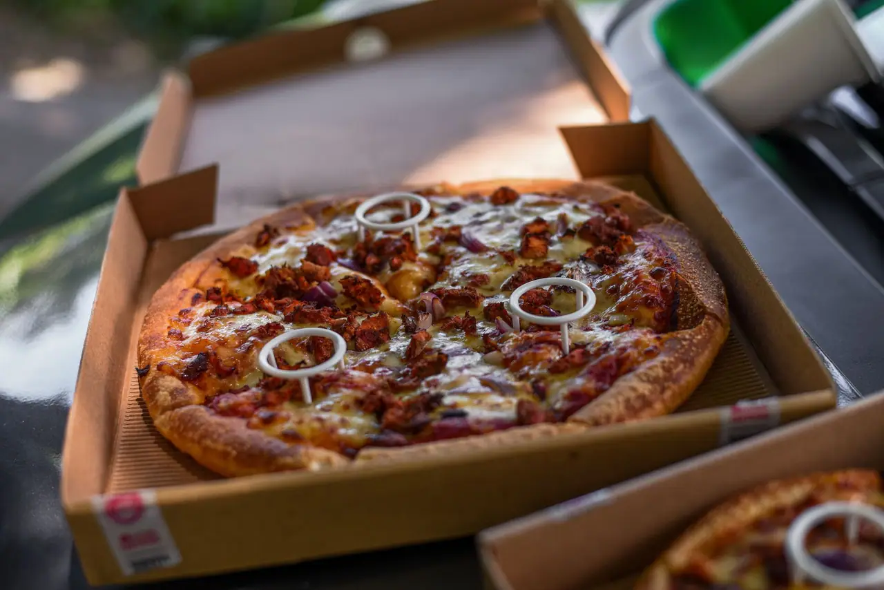 Pizza in an open kraft corrugated pizza box